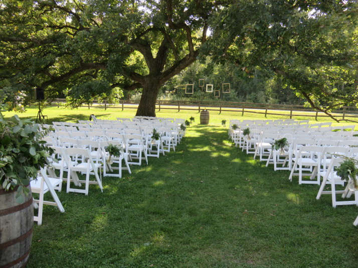Picture frames and simple greenery decorate outdoor ceremony space